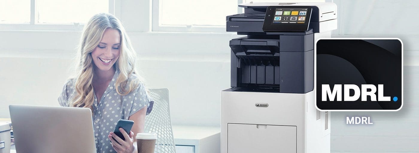 Application My Digital Registered Letter Femme souriante travaille devant ordinateur et téléphone portable à côté d'une imprimante Xerox